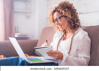 Bright Window Light Image For Caucasian Beautiful Middle Age Woman Working At Home With Laptop And Notebook. Writing A Note On The Book With A Pen Like Old Style But Use Internet On The Computer