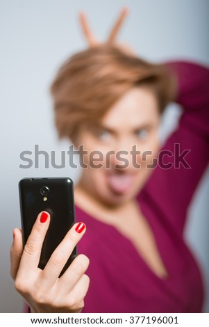 bright woman having fun photographs on the phone with glasses isolated studio