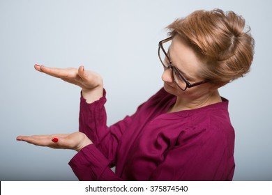 Bright Woman Holding Something Invisible In Hands Isolated Studio