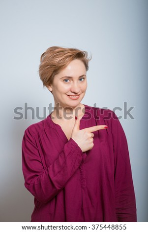 bright woman points to someone in the side, isolated studio