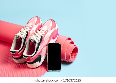 Bright Women's Sneakers With Smartphone And Pink Yoga Mat. App For Training Indoors. Online Fitness Program. Home Online Workout.