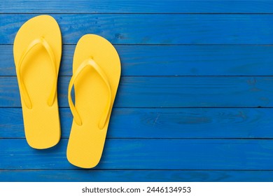 Bright yellow flip-flops on wooden background, top view. Summer concept - Powered by Shutterstock