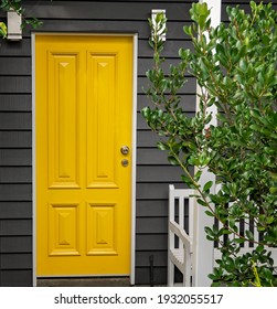 A bright yellow front entrance door in a renovated old Queensland home