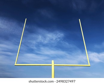 A bright yellow goal post against a dark blue and cloudy sky - Powered by Shutterstock