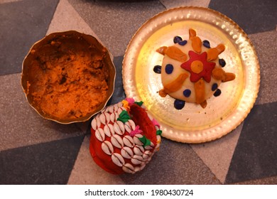 a bright yellow haldi kept on a yellow bowl a plate of sweets and a red box used during bengali traditional marriage 