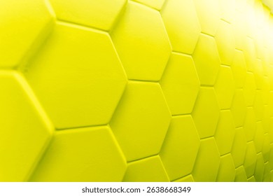 Bright yellow hexagonal tiles create striking textured surface on modern wall, adding touch of contemporary design and visual interest to space. Bright yellow hexagonal tiles forming geometric pattern