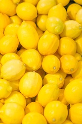 Lot Of Bright Yellow Lemons In Supermarket