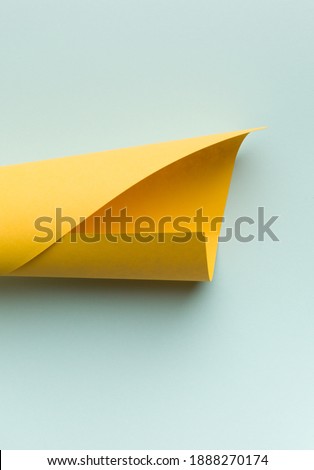 The bright yellow sheet paper on a on lite blue background.