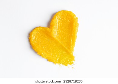 Bright yellow swatches of the mango body scrub.
Skincare cosmetic cream lotion swatch smear smudge on white color background. Scrub hygiene beauty product close up