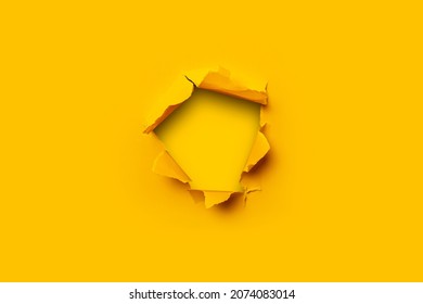 Bright yellow torn paper inside in a hole yellow cardboard background - Shutterstock ID 2074083014