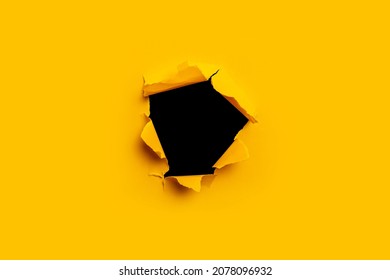 Bright yellow torn paper inside a black hole in a hole - Shutterstock ID 2078096932