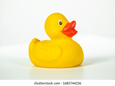 Bright yellow toy duck against white