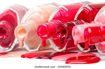 Bright-colored nail polish spilling from bottles