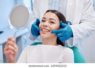 The brightest smile in the room. Shot of a young woman checking her results in the dentists office. - Powered by Shutterstock