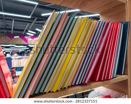 Brightly colored hardbound notebooks arranged in rows on a store shelf, perfect for jotting down notes
