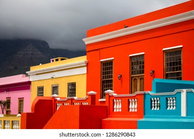 The brightly colored houses of Bo-Kaap, Cape Town. South Africa. The stunning view of Signal Hill from Bo-Kaap, the Cape Malay Quarter. The famous tourist attraction. British style colorful buildings. - Powered by Shutterstock