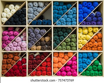 Brightly Colored Skeins Of Wool Organized By Color On  Triangular Shelves