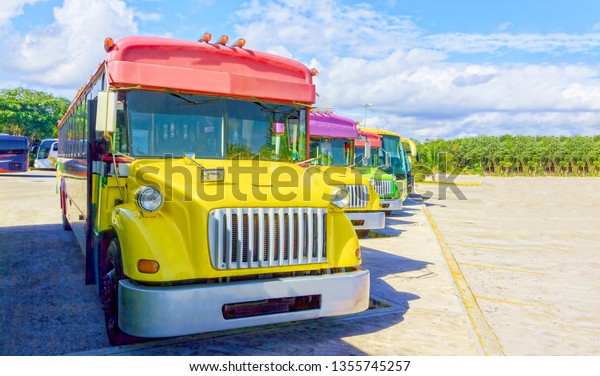 Brightly painted tourist buses stand in a row in a
large parking lot. Buses await tourists who come to relax in a
large tropical park.
