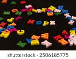 Brightly painted wooden letters spelling "HOPE" centered against a black background. The vibrant colors contrast sharply with the dark backdrop, conveying optimism.