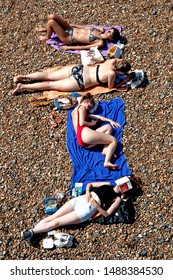 Brighton Beach, Sussex, England, August 2019. Young Women Sunbathe On Brighton Beach In The Record Breaking Hot Temperatures Of 2019.

