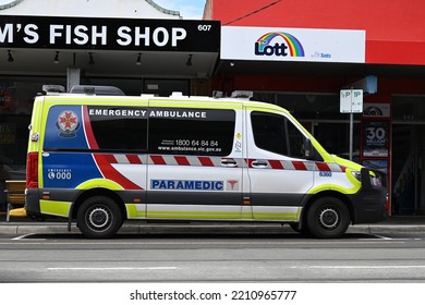 Brighton East, Victoria, Australia - October 6 2022: Side View Of An Ambulance Victoria Emergency Ambulance Vehicle Parked On The Side Of A Road In A Shopping Strip, With Shops In The Background