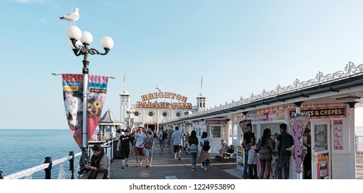 BRIGHTON, ENGLAND - JULY 9, 2018: Tourists in Brighton Palace Pier on Brighton beach, Brighton, UK. The pleasure pier opened in 1899 is a Grade II listed heritage structure in UK. 