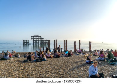 Brighton, UK: 30 March 2021: People on Brighton Beach by West Pier, East Sussex