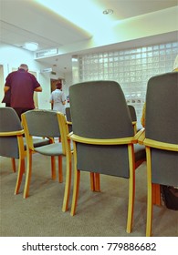 Brighton UK, December 22 2017 - A Patient Walking Following A Nurse To Get Seen By Doctor From A Waiting Room With Chairs At A Surgery Clinic