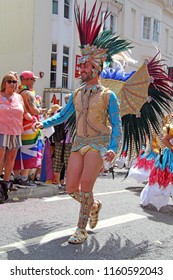 Brighton,East Sussex/UK 08-04-18 Brighton's Pride Parade 2018. A Male Exotic Dancer In A Feathered Costume Makes His Way Up West Street In The City Centre.