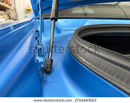 A brilliant close-up of an open trunk on a vibrant blue Dodge Challenger RT, highlighting the sleek automotive design, hydraulic lift strut, and premium rubber weatherstripping seal.