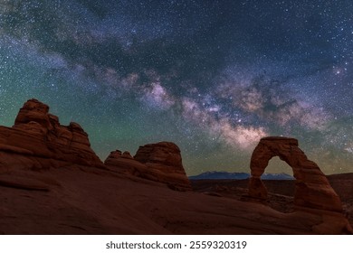 A brilliant, colorful Milky Way rises behind Delicate Arch over the La Sal Mountains in Arches National Park, Utah. - Powered by Shutterstock