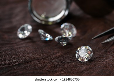 Brilliant Cut Diamond Held By Tweezers On Leather Background