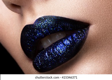 Brilliant glossy lips closeup. Purple glitter on black lipstick