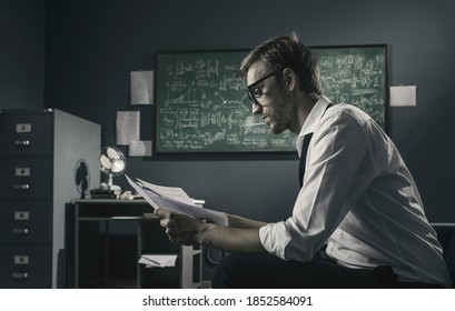 Brilliant Mathematician Working In His Office, He Is Reviewing His Papers And Checking Math Formulas, Scientific Research Concept