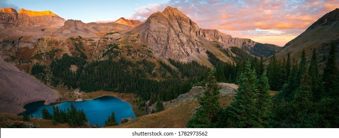 A brilliant sunrise at the lower Blue Lake in Mount Sneffels Wilderness, Ridgeway, Colorado during the falls season. A backpacking adventure. 
