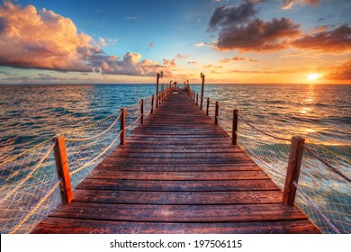 Brilliant sunrise on a sea pier with azure waters 