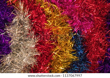 Brilliant tinsel of red, blue, purple, silver and gold. Decoration for the Christmas tree and for the house.