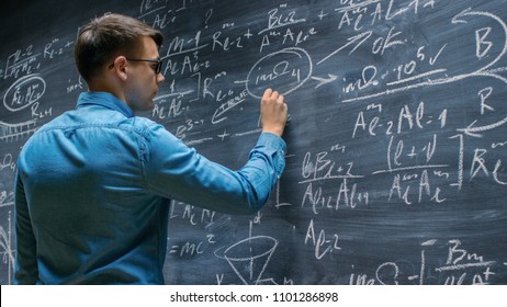 Brilliant Young Mathematician Approaches Big Blackboard and Finishes writing Sophisticated Mathematical Formula/ Equation. - Powered by Shutterstock