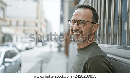 Brimming with joy, middle age man with grey hair stands confidently on city street, his smile beaming happiness as he subtly laughs, his mature expression telling tales of a fulfilled life.
