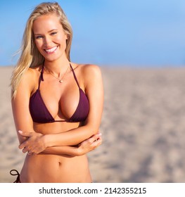 Bring on the sun. A sun kissed woman relaxing on the beach in a bikini.