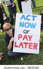 BRISBANE, AUSTRALIA - JUNE 6 : Woman With Act Now Or Pay Later Anti Pollution Sign At Say Yes To Carbon Tax World Environment Day Protest 6, 2011 In Brisbane, Australia