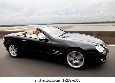 Brisbane, QLD Australia 01/25/2020: A Very Nice Black Classy Convertible Sports Car Being Driven Around By A Mature Couple.