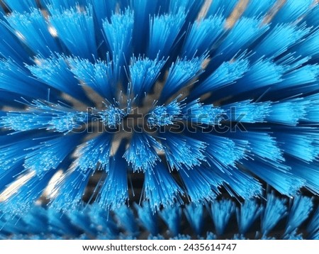 Bristle brush. Close-up photo of a domestic tool resembling butches of optical fiber. Abstract technology and industry background.