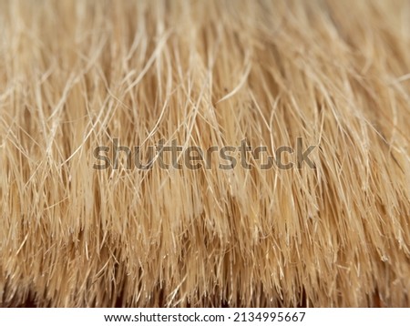 The bristles of the paintbrush. Macro photo. Soft focus.  Macro photography of paint brush bristles, shallow depth of field, focus in the center. Abstract textured light yellow background.