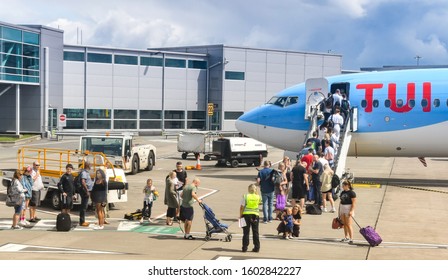 BRISTOL, ENGLAND - AUGUST 2019:  Passengers Boarding Through The Front Door Of A TUI Boeing 737 Holiday Jet At Bristol Airport.