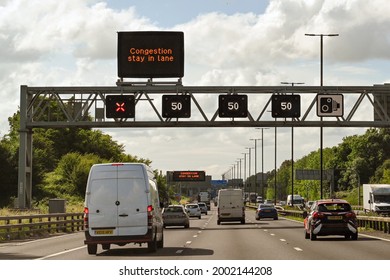 Bristol, England - June 2021: Overhead gantry on the M4 motorway with road signs showing the speed limit and a closed lane.