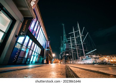 Bristol, UK - August 04 2021: Long Exposure Of People Walking Beside City Docks At Night