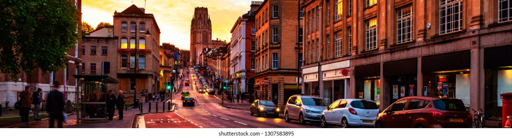 Bristol, UK. Famous street in the center of Bristol, UK in the evening during the colorful sunset. Bright cloudless sky at night. Various shops, cafes and restaurants.