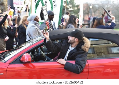 Bristol, UK - February 4, 2017: A Bystander In A Car Uses A Smartphone To Photo Protesters Marching Against US President Donald Trump's Upcoming Visit To The UK.