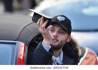 Bristol, UK - February 4, 2017: A Bystander In A Car Uses A Smartphone To Photo Protesters Marching Against US President Donald Trump's Upcoming Visit To The UK.